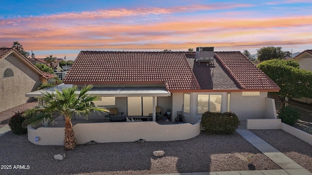 back of house with a patio, a tiled roof, central AC unit, and stucco siding