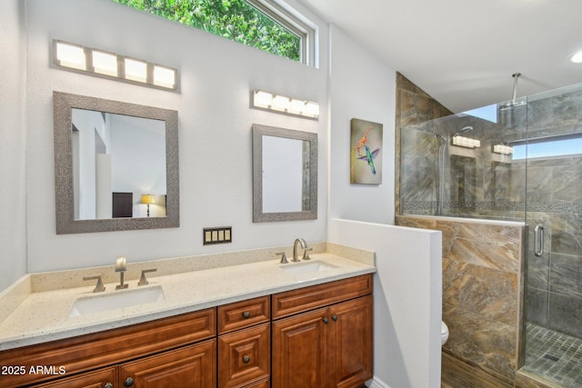 full bathroom with a stall shower, a sink, toilet, and double vanity