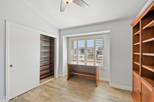 unfurnished office with a ceiling fan, vaulted ceiling, light wood-style flooring, and baseboards