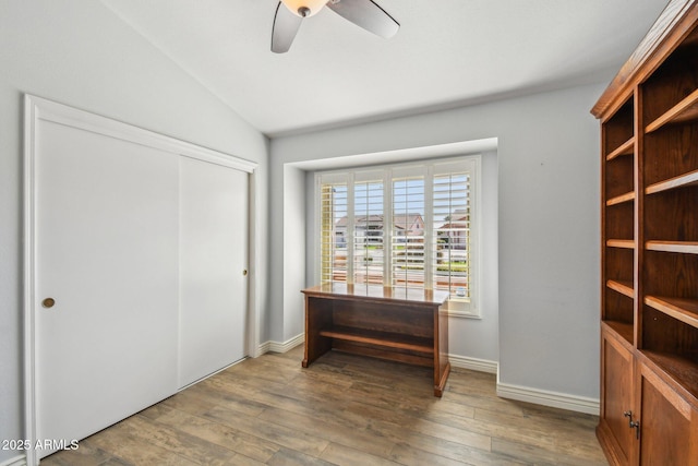 interior space with vaulted ceiling, ceiling fan, wood-type flooring, and baseboards