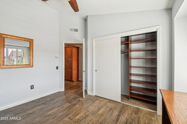 unfurnished bedroom featuring visible vents, baseboards, ceiling fan, dark wood-style flooring, and a closet