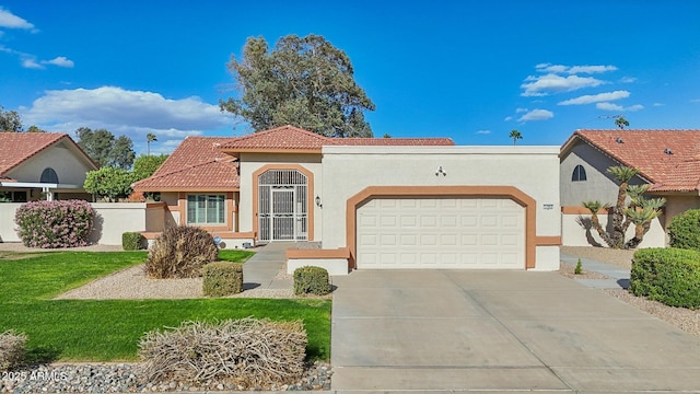 mediterranean / spanish house with stucco siding, concrete driveway, an attached garage, fence, and a tiled roof