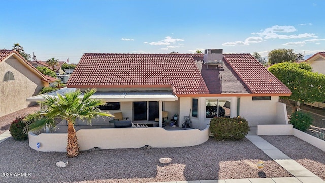 rear view of property with a patio, cooling unit, a tiled roof, and stucco siding