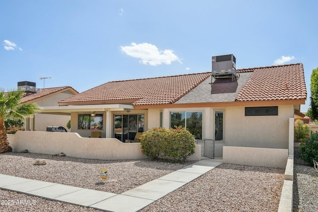 rear view of house featuring stucco siding and central air condition unit