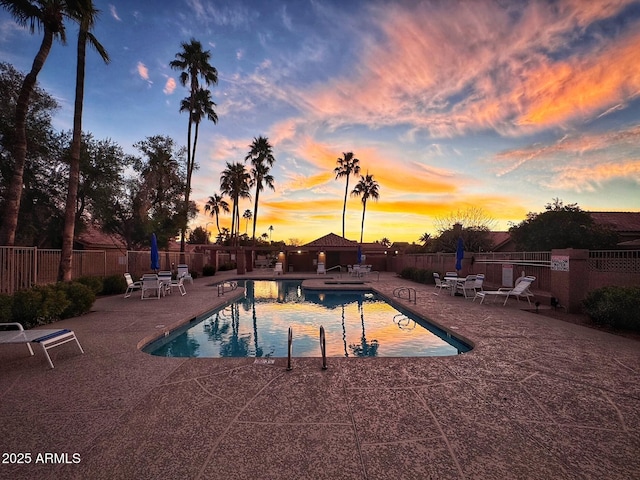 pool at dusk with a patio area