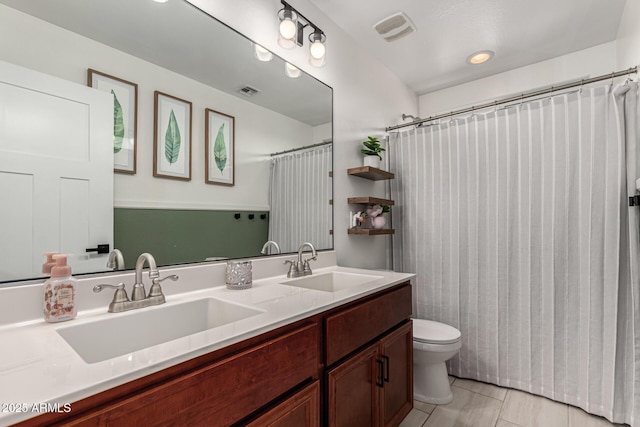 bathroom featuring toilet, vanity, tile patterned floors, and walk in shower