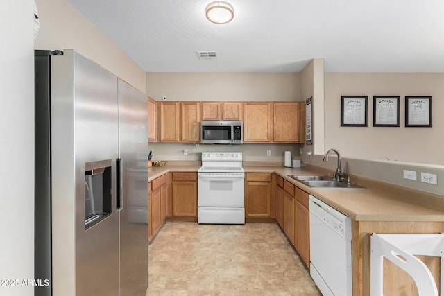 kitchen featuring appliances with stainless steel finishes, light countertops, a sink, and visible vents