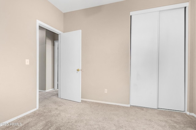 unfurnished bedroom featuring carpet floors, a closet, and baseboards