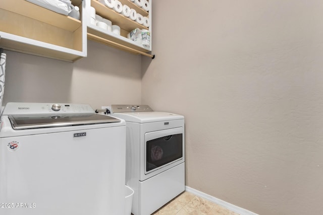 washroom with laundry area, baseboards, and washer and dryer