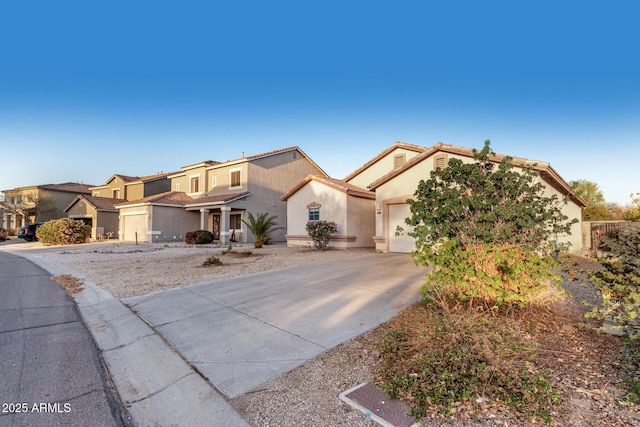 view of front facade with driveway, an attached garage, a tile roof, and stucco siding