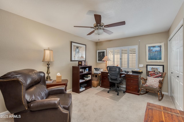 office area with light carpet, baseboards, and a ceiling fan