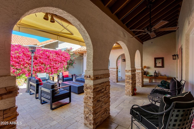 view of patio with an outdoor living space with a fire pit and ceiling fan
