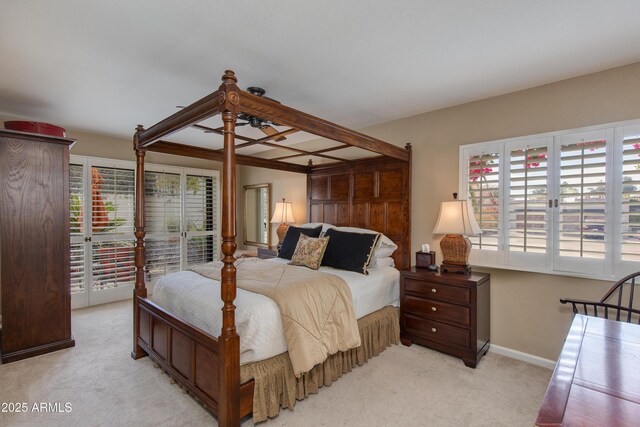 bedroom featuring light colored carpet and baseboards