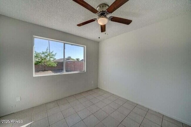 spare room featuring ceiling fan, a textured ceiling, and light tile patterned floors
