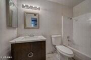 bathroom with toilet, vanity, and washtub / shower combination