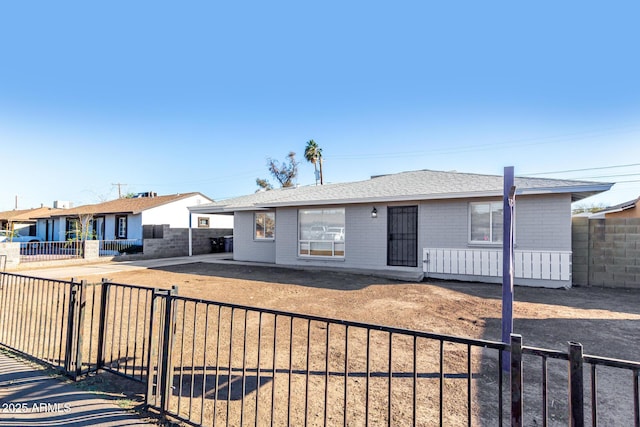 ranch-style house with a shingled roof and fence private yard