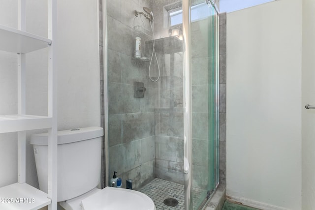 bathroom with a shower with door and toilet