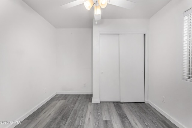 unfurnished bedroom featuring hardwood / wood-style flooring, ceiling fan, and a closet