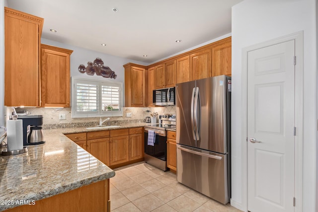 14000 N 94th St N Unit 1129, Scottsdale, AZ 85260 - kitchen featuring appliances with stainless steel finishes, tasteful backsplash, light stone countertops, and brown cabinets