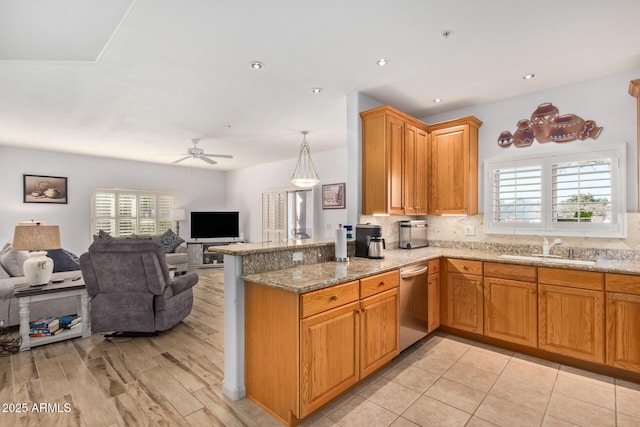 14000 N 94th St N Unit 1129, Scottsdale, AZ 85260 - kitchen featuring stainless steel dishwasher, open floor plan, ceiling fan, light stone counters, and a peninsula