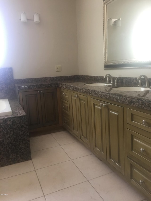 full bath with tile patterned flooring, tiled bath, and vanity