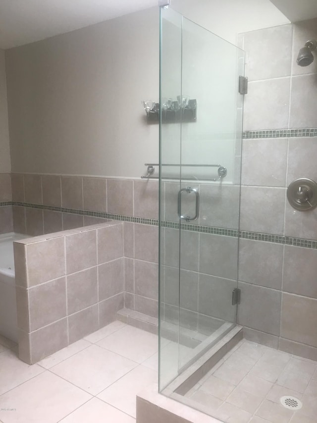 bathroom with a shower stall and tile patterned floors