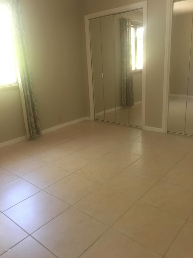 empty room featuring light tile patterned floors and baseboards