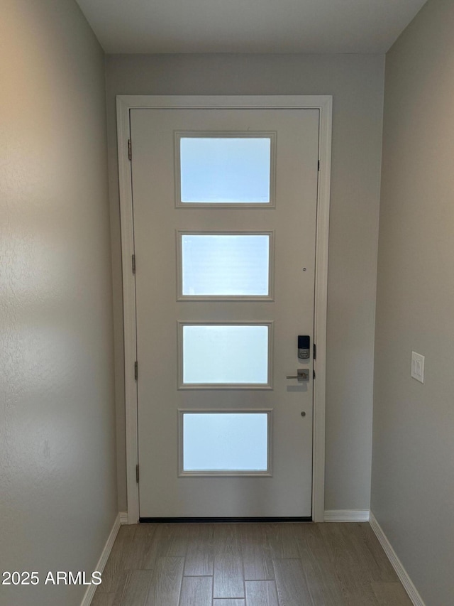 doorway to outside with light wood-style floors and baseboards