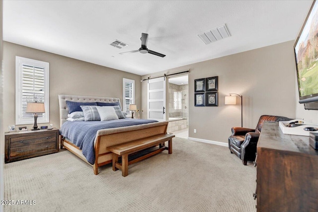 bedroom featuring multiple windows, light carpet, a barn door, and visible vents