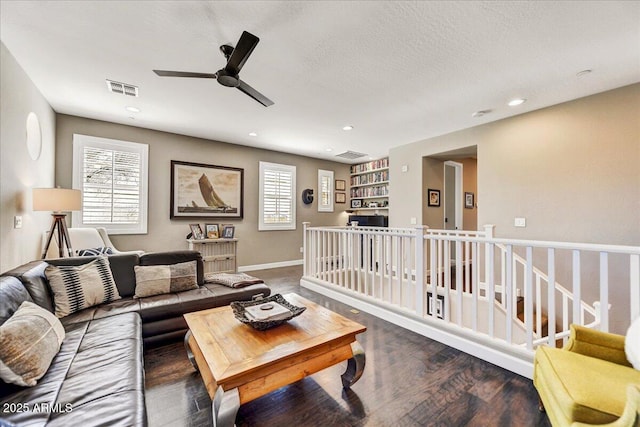 living room featuring visible vents, wood finished floors, ceiling fan, and a healthy amount of sunlight