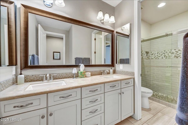 bathroom featuring toilet, a sink, and a shower stall