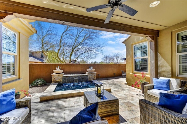 view of patio featuring outdoor lounge area, fence, and a ceiling fan