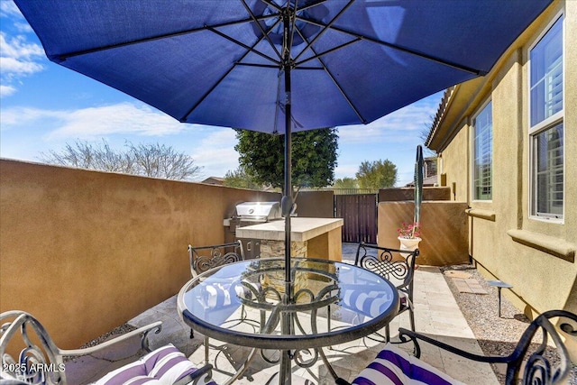view of patio / terrace featuring outdoor dining space, an outdoor kitchen, area for grilling, and fence