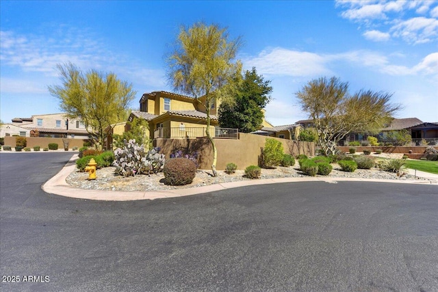 exterior space featuring a residential view, a tile roof, stucco siding, and fence