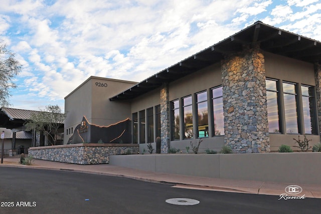 view of side of property with stone siding and stucco siding