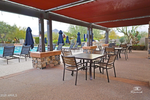 view of patio with a community pool and outdoor dining area