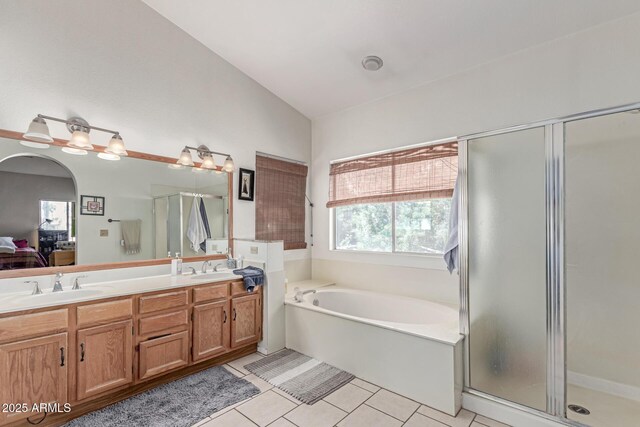 full bath with double vanity, plenty of natural light, a sink, and tile patterned flooring