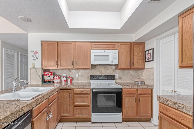 kitchen featuring dishwasher, white microwave, a sink, light tile patterned floors, and range with electric cooktop