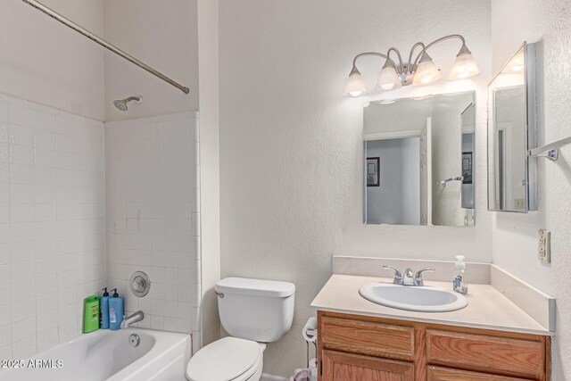 bathroom with vanity,  shower combination, a textured wall, and toilet