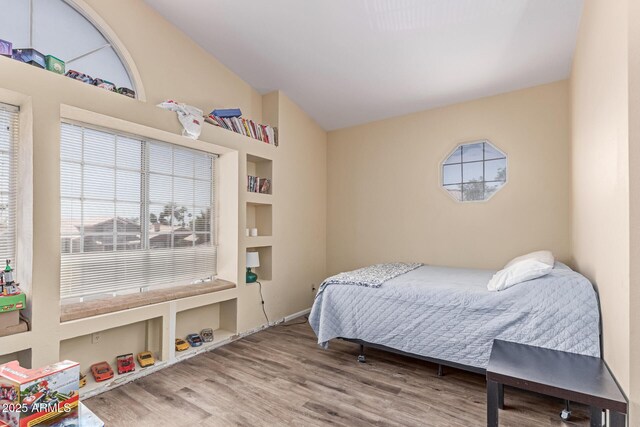 bedroom featuring wood finished floors and vaulted ceiling