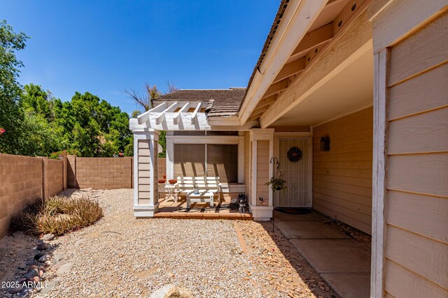 property entrance with a patio, fence, and a pergola