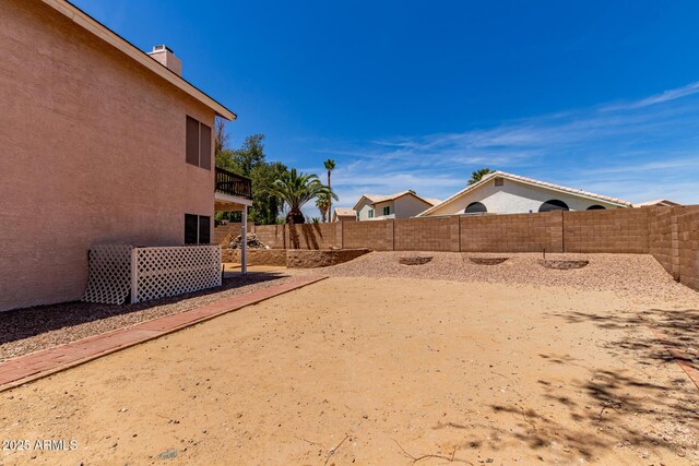 view of yard featuring a fenced backyard and a balcony