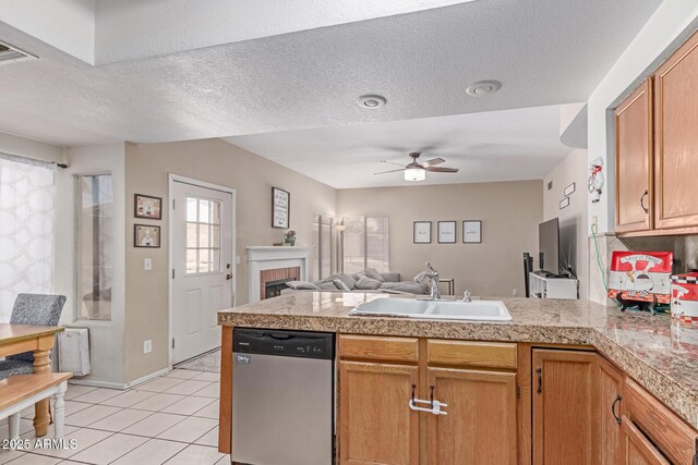 kitchen featuring a sink, tile counters, a ceiling fan, open floor plan, and stainless steel dishwasher