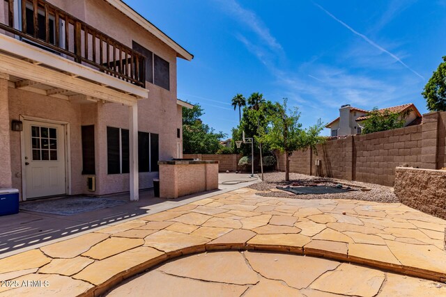 view of patio featuring a fenced backyard and a balcony