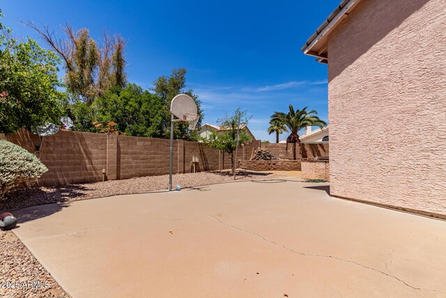 view of patio / terrace featuring a fenced backyard and basketball hoop