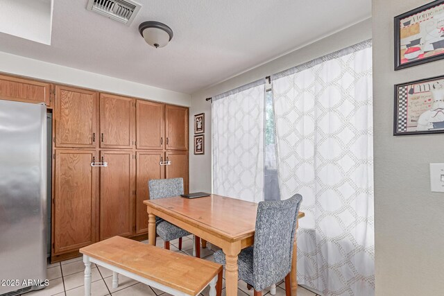 dining area with light tile patterned flooring and visible vents