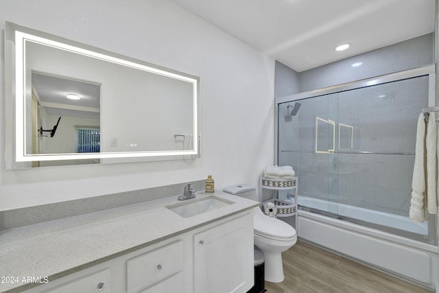 full bathroom with toilet, vanity, enclosed tub / shower combo, and hardwood / wood-style flooring