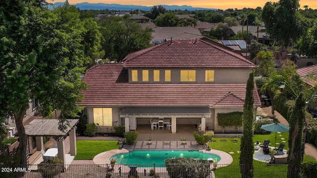 back of property with a patio, fence, a lawn, and stucco siding