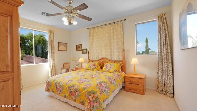 carpeted bedroom featuring visible vents, baseboards, and ceiling fan