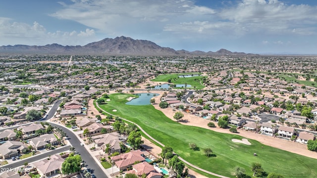 drone / aerial view featuring view of golf course, a residential view, and a water and mountain view